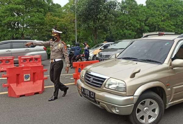 Polisi mengatur lalu lintas di pos penyekatan PPKM darurat di Budaran Waru, Surabaya